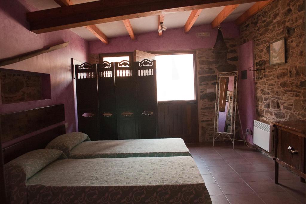 塞代拉卡尔萨达罗马娜旅馆的紫色墙壁客房里一间卧室,配有一张床