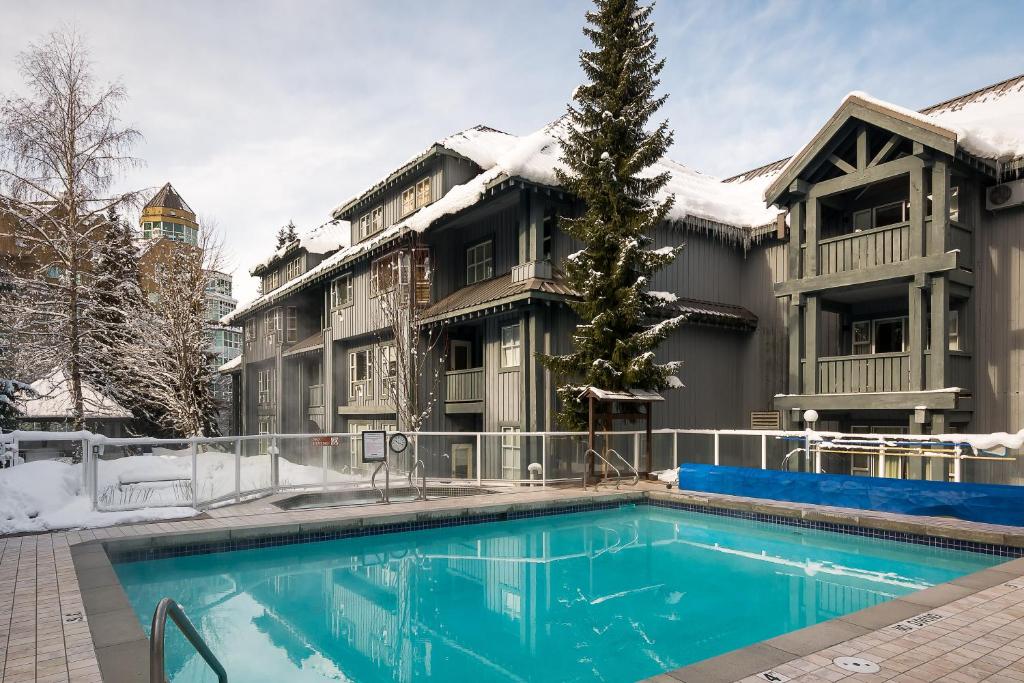 惠斯勒Glacier Lodge的雪中带游泳池的房子