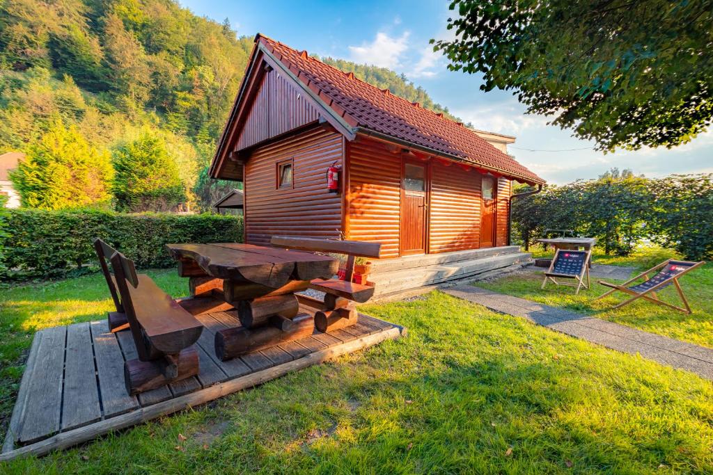 卡姆尼克Počitniška hiška Pod Skalco的小木屋设有野餐桌和长凳