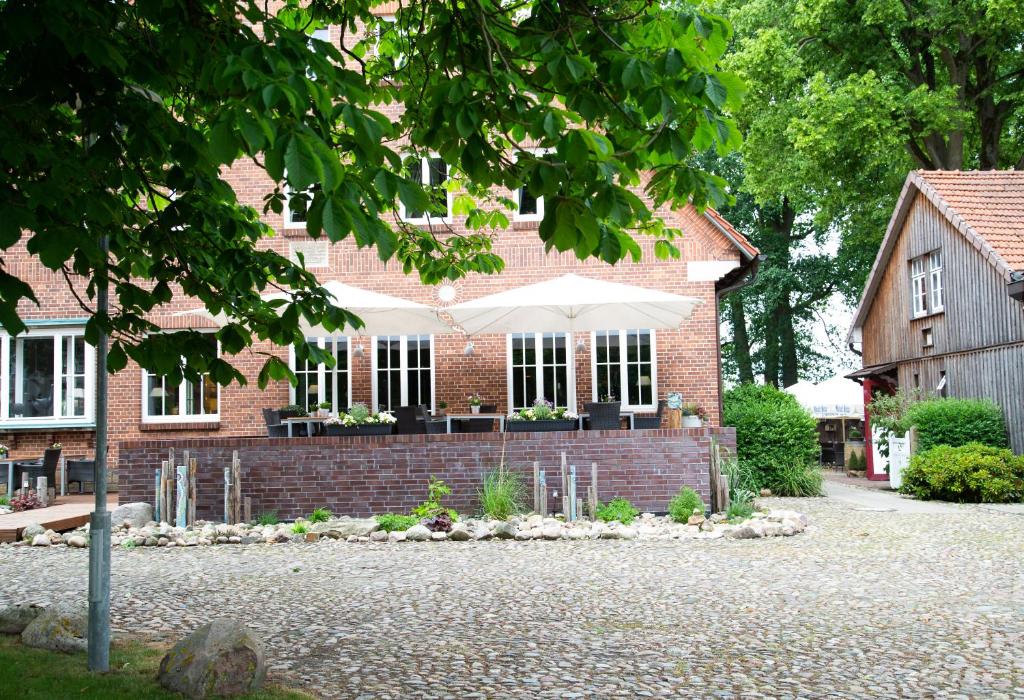 WolthausenLandgasthof Wildwasser的前面有白色雨伞的砖房