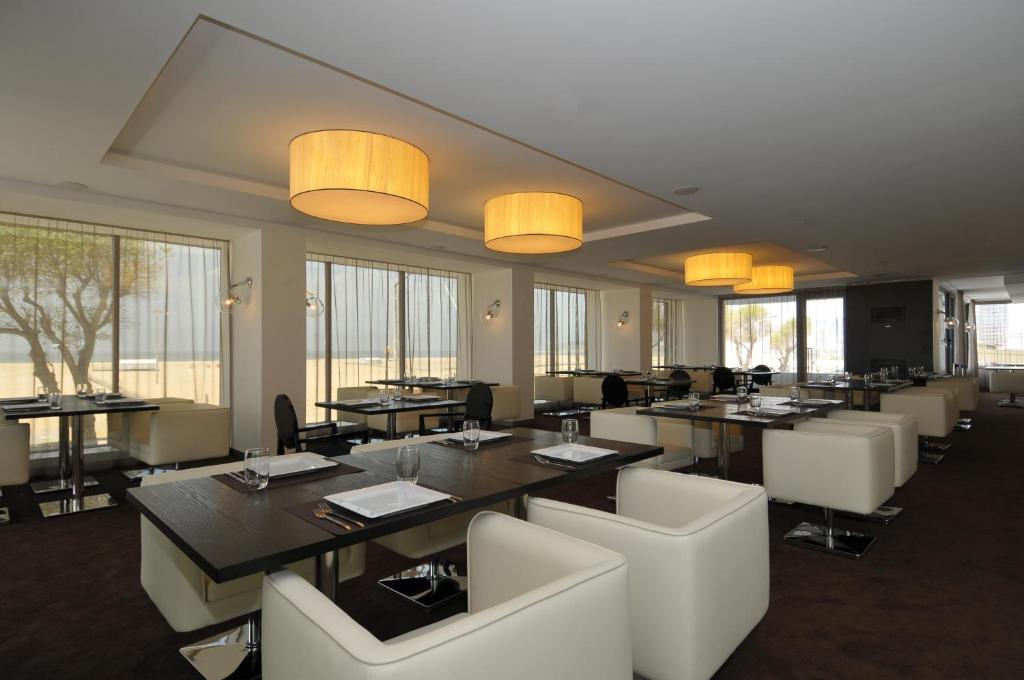 菲盖拉-达福什甜蜜大西洋酒店暨Spa的用餐室设有桌椅和窗户。