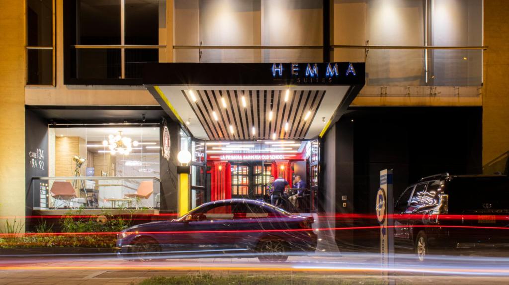 波哥大Hemma Bogotá Luxury Suites Hotel的停车场停在大楼前