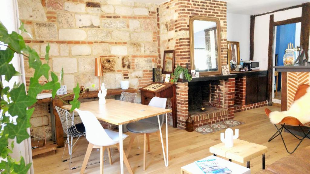 翁弗勒尔-La Batisse -Parking privé -Coeur historique - La Clef de Honfleur的一间设有桌子和砖墙的用餐室