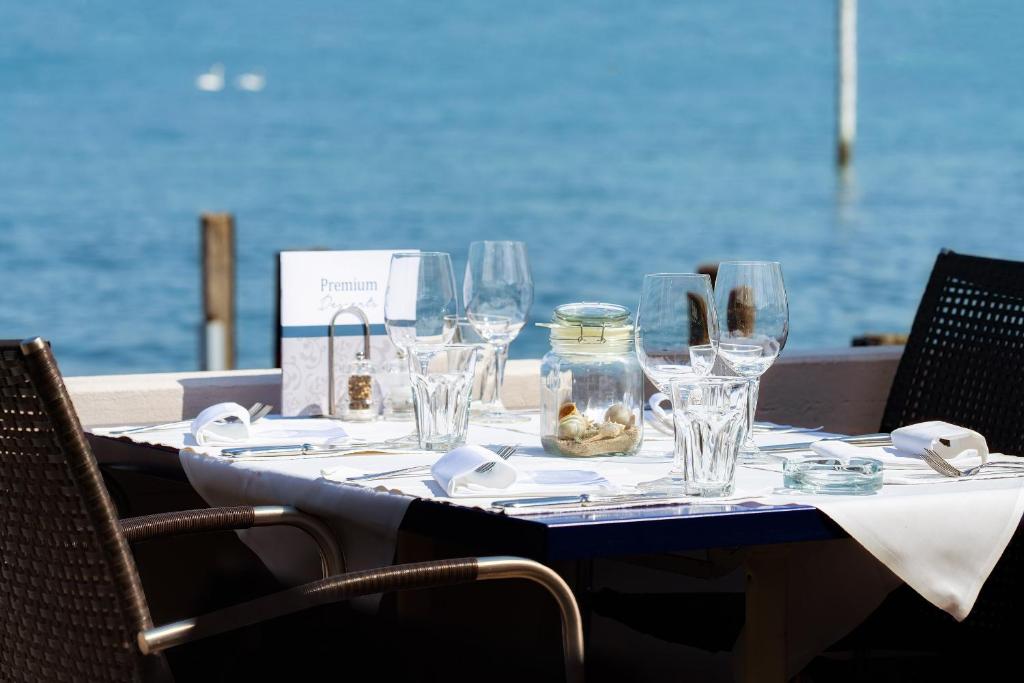 斯坦斯施塔德温克里德湖畔酒店的酒杯桌子,后面是大海