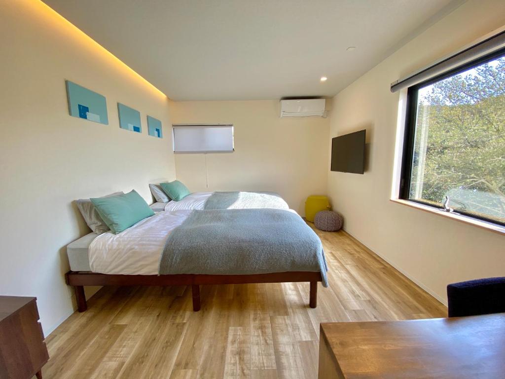 直岛町BATONWORKS Naoshima的一间卧室设有一张床和一个大窗户