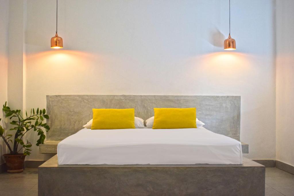 科伦坡City Beds Colombo的一间卧室配有一张带两个黄色枕头的床