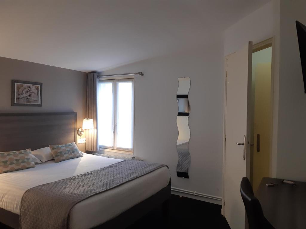 圣西尔-莱科勒圣西尔凡尔赛阿罗特尔酒店 - 寂静的舞台的一间卧室设有一张大床和一个窗户。