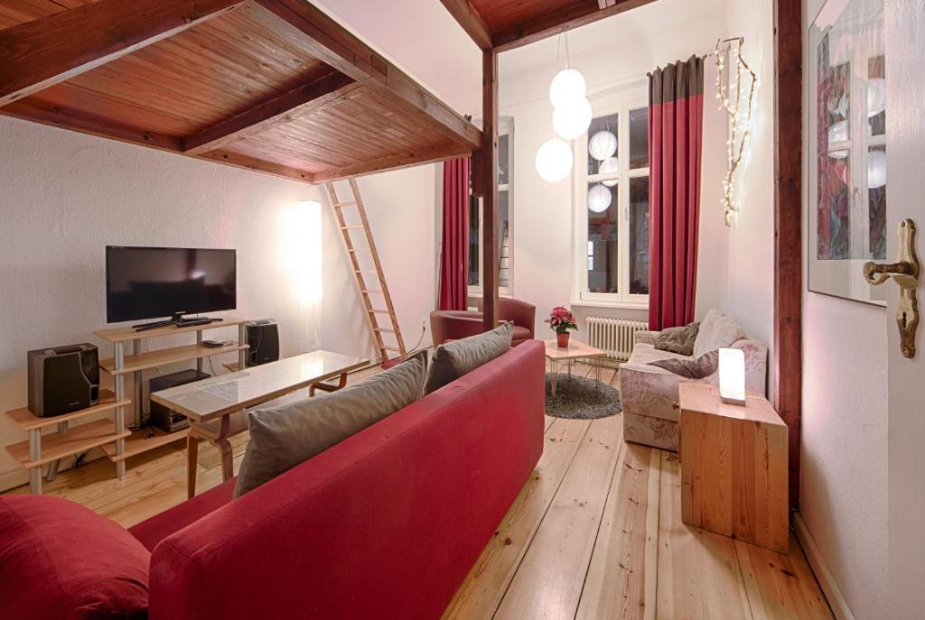柏林Ruhige Ferienwohnung in Kreuzberg的客厅配有红色沙发和电视