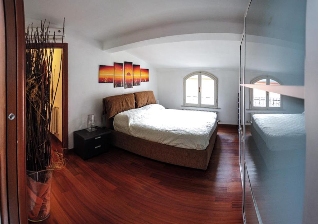 卡拉拉STUPENDA MANSARDA CENTRALISSIMA, finiture di lusso的一间卧室设有一张大床和一个玻璃门