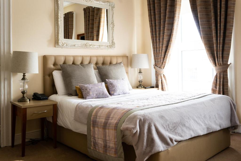 特里姆Brogans Bar & Hotel的一间卧室配有一张带镜子的床和窗户