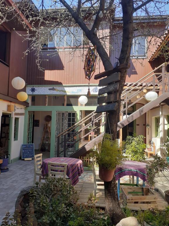 圣地亚哥Eco-Hostal Tambo Verde的一座配有桌椅和一棵树的建筑