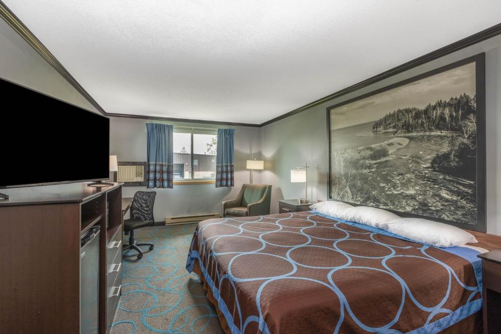 德卢斯德卢斯速8酒店的配有一张床和一台平面电视的酒店客房