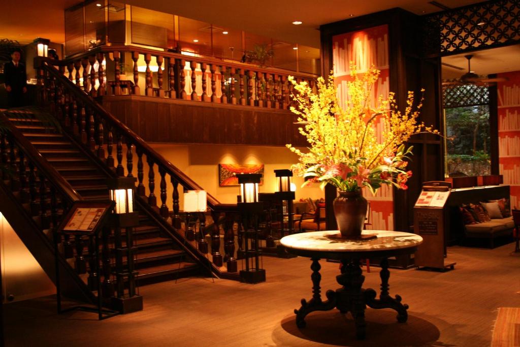 甲府Konaya Hotel的一间设有楼梯的房间和一张花瓶桌子