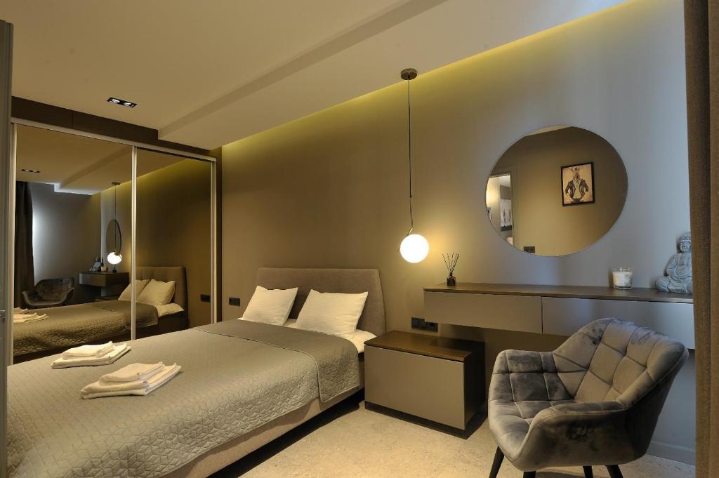 克卢日-纳波卡Sofia Apartments的一间卧室配有一张床、一把椅子和镜子