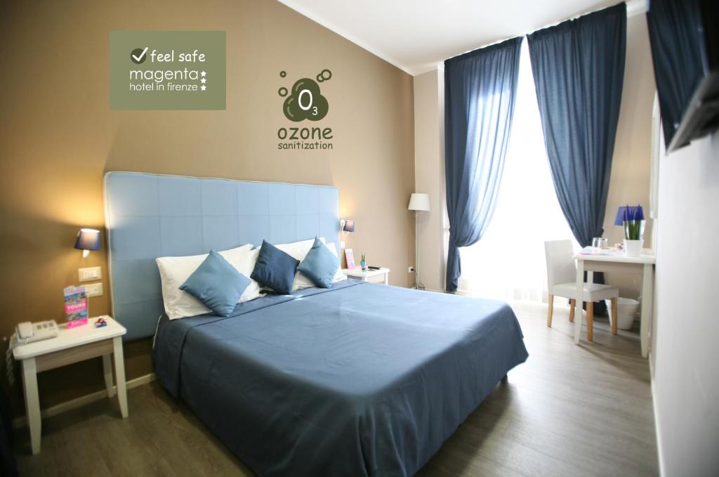 佛罗伦萨品红酒店的一间卧室配有蓝色的床和蓝色的床单