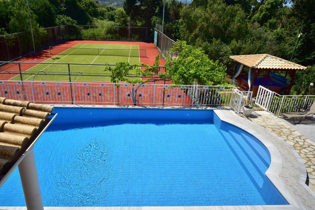 罗达Villa Jolie Corfu Roda的一个带网球场的大型蓝色游泳池