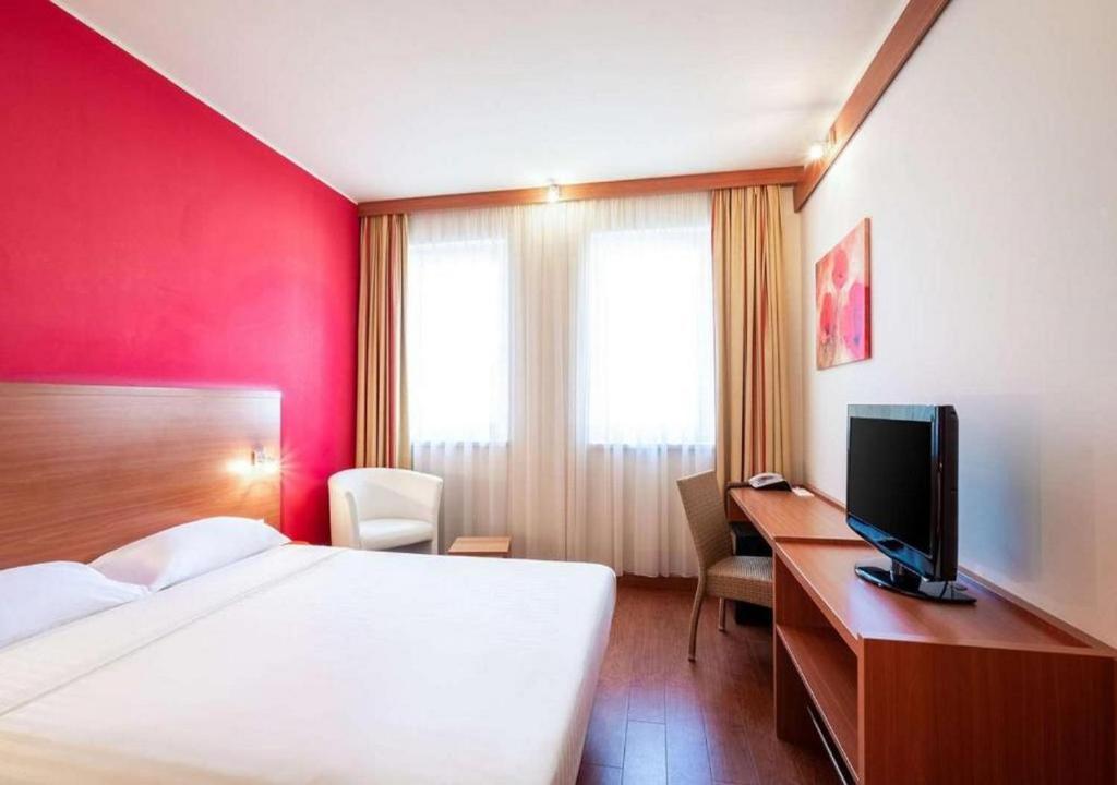 布达佩斯City Hotel Budapest的酒店客房配有一张床和一张书桌及一台电视
