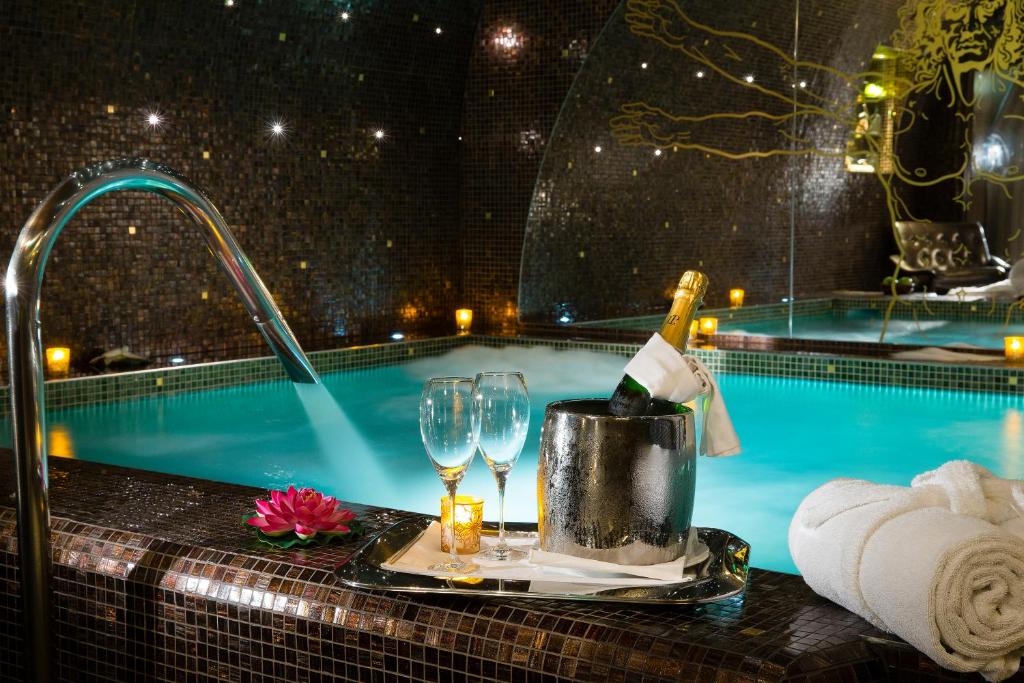巴黎达芬奇酒店及Spa的游泳池旁的桌子,上面有一瓶葡萄酒和玻璃杯