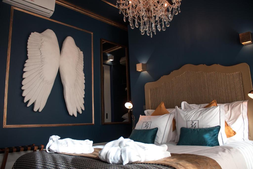 塞图巴尔34 GuestHouse的卧室配有一张壁挂天使翼的床