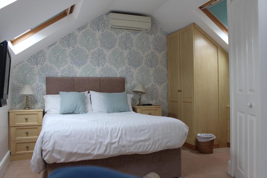 约克格兰奇旅馆的一间卧室配有一张带蓝色壁纸的大床