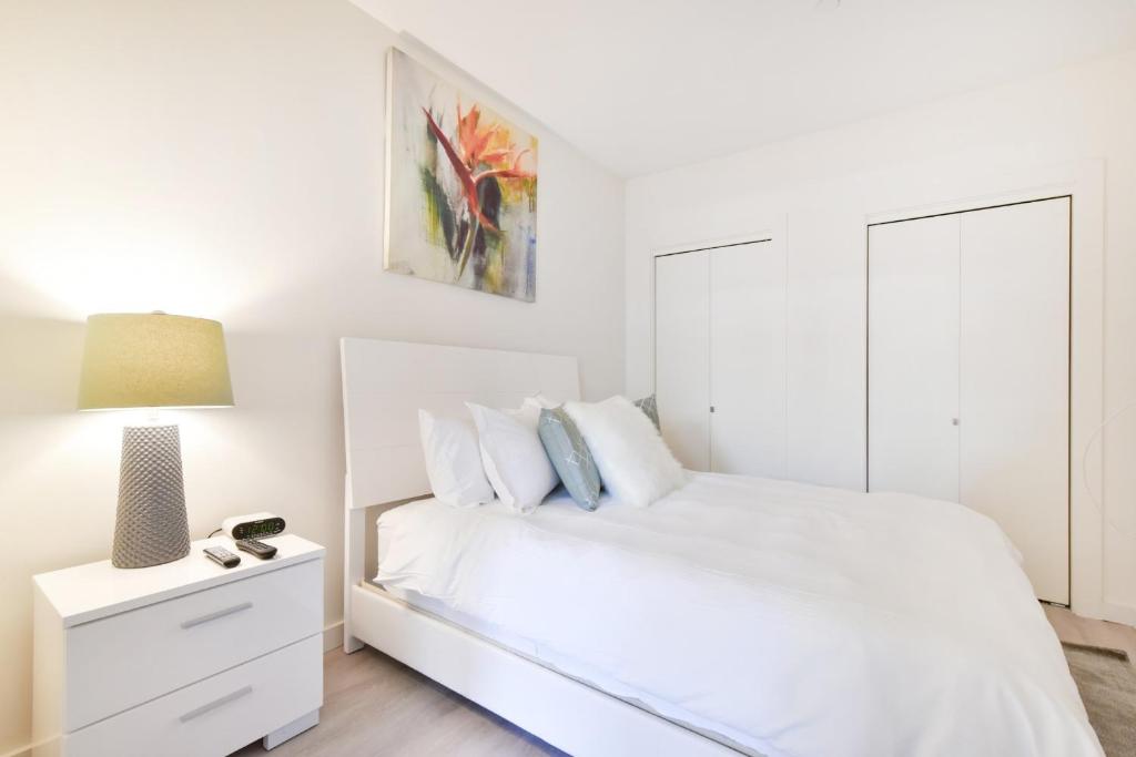 波士顿Global Luxury Suites Downtown Boston的白色卧室配有白色的床和灯