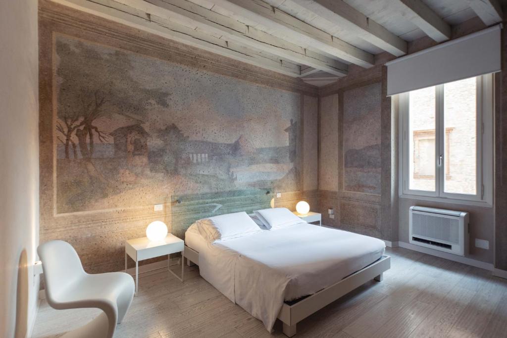 曼托瓦Scaravelli Residenza的卧室配有一张床,墙上挂有绘画作品