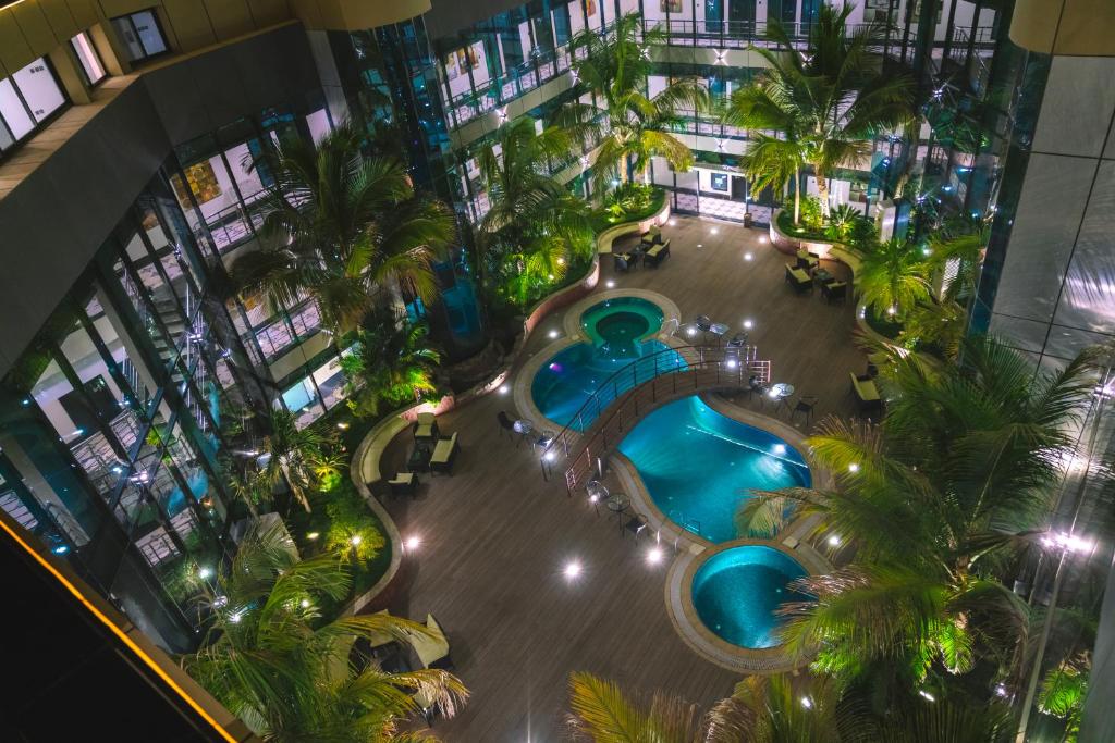 吉达Andalus Habitat Hotel的棕榈树建筑中游泳池的顶部景色