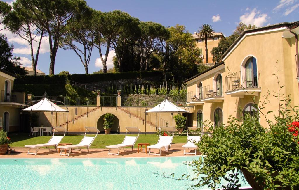 东塞斯特里阿格尼斯别墅酒店的房屋旁的游泳池配有椅子和遮阳伞