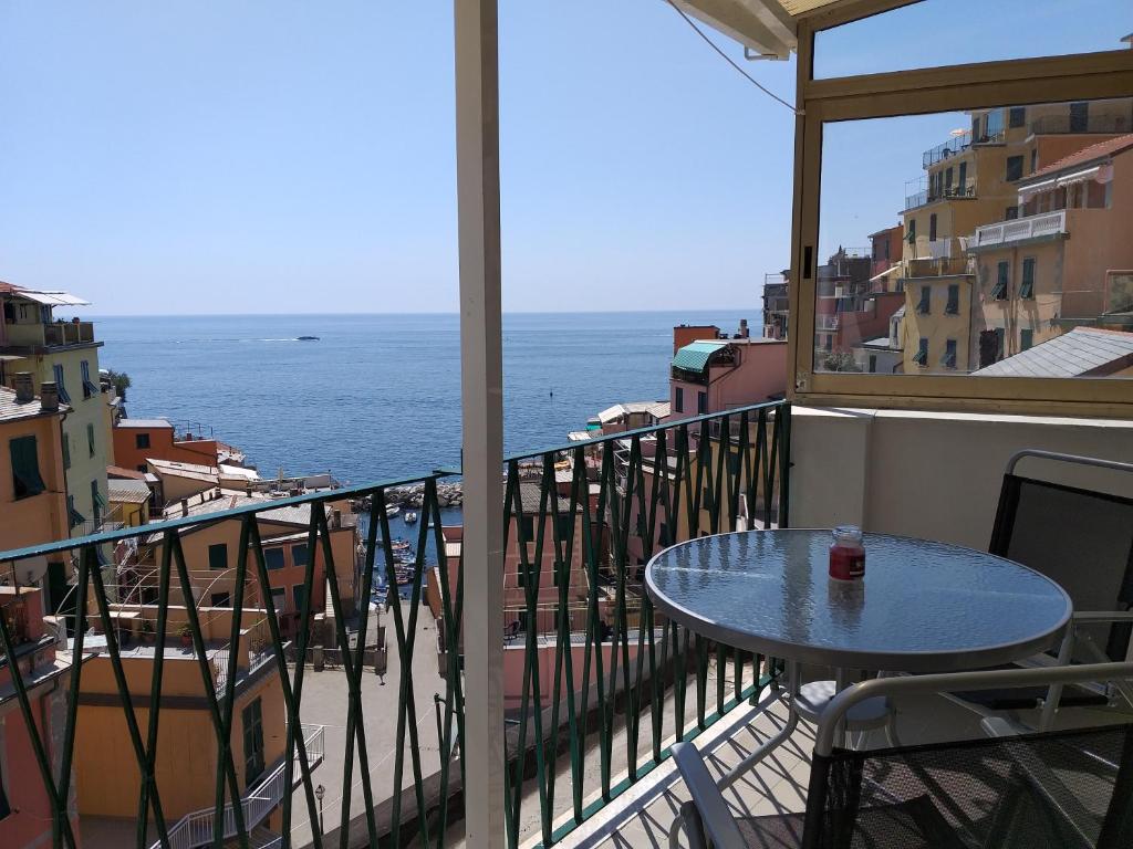 里奥马哲雷Aa Ciasèa duu Pintùu的阳台配有桌子,享有海景。