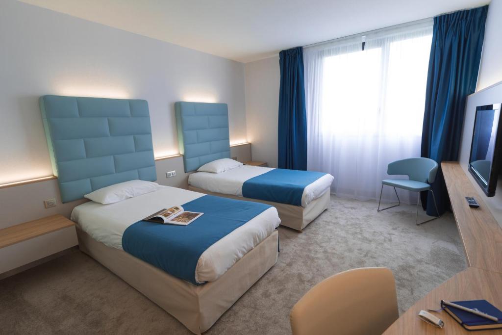 沙斯讷伊迪普瓦图广场酒店的酒店客房设有两张床和电视。