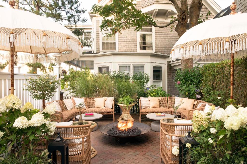 楠塔基特Life House, Nantucket的一个带桌椅和遮阳伞的庭院