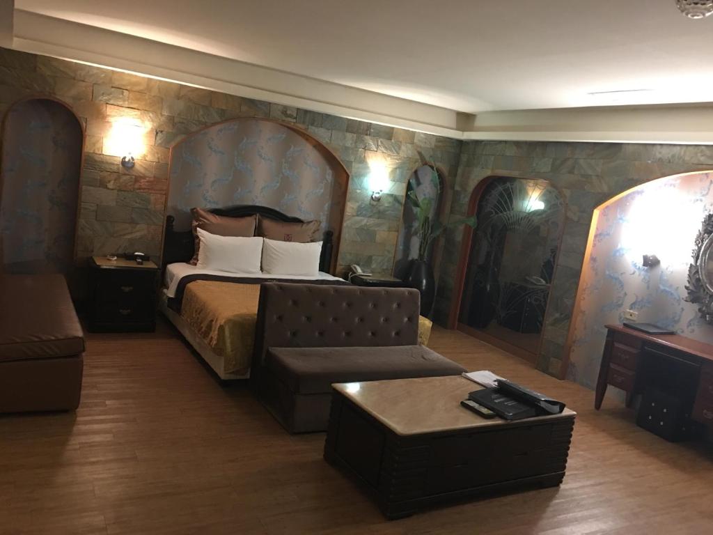 土城区探索(探情)汽车旅馆-土城馆的酒店客房,配有床和沙发