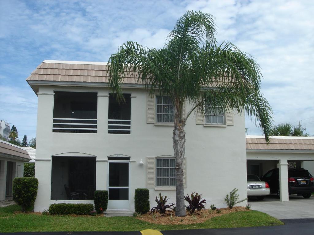 西耶斯塔岛Island House Beach Resort 10A的白色房子前面的棕榈树