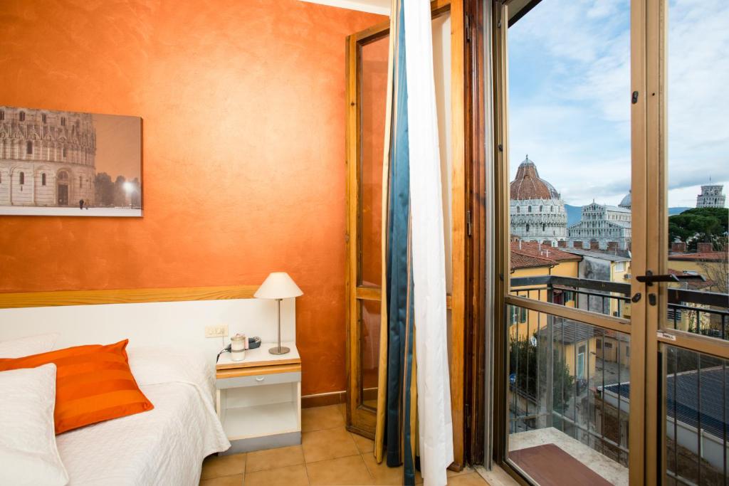 比萨罗马酒店的一间卧室设有一张床和一个大窗户