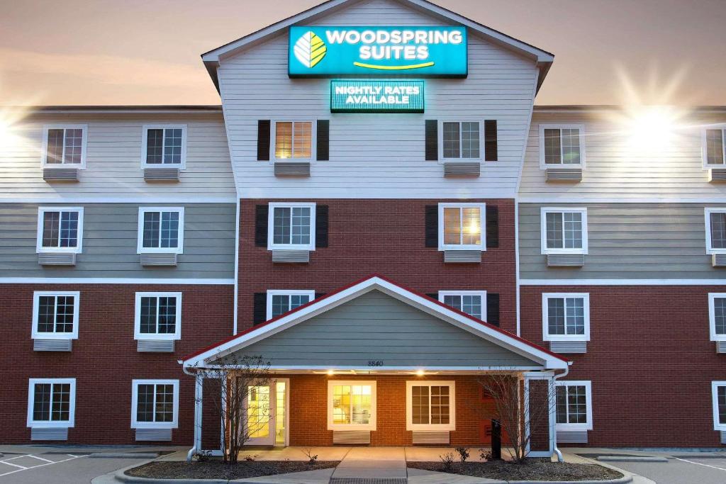 罗利WoodSpring Suites Raleigh Northeast Wake Forest的一座建筑,上面有读木工套的标志