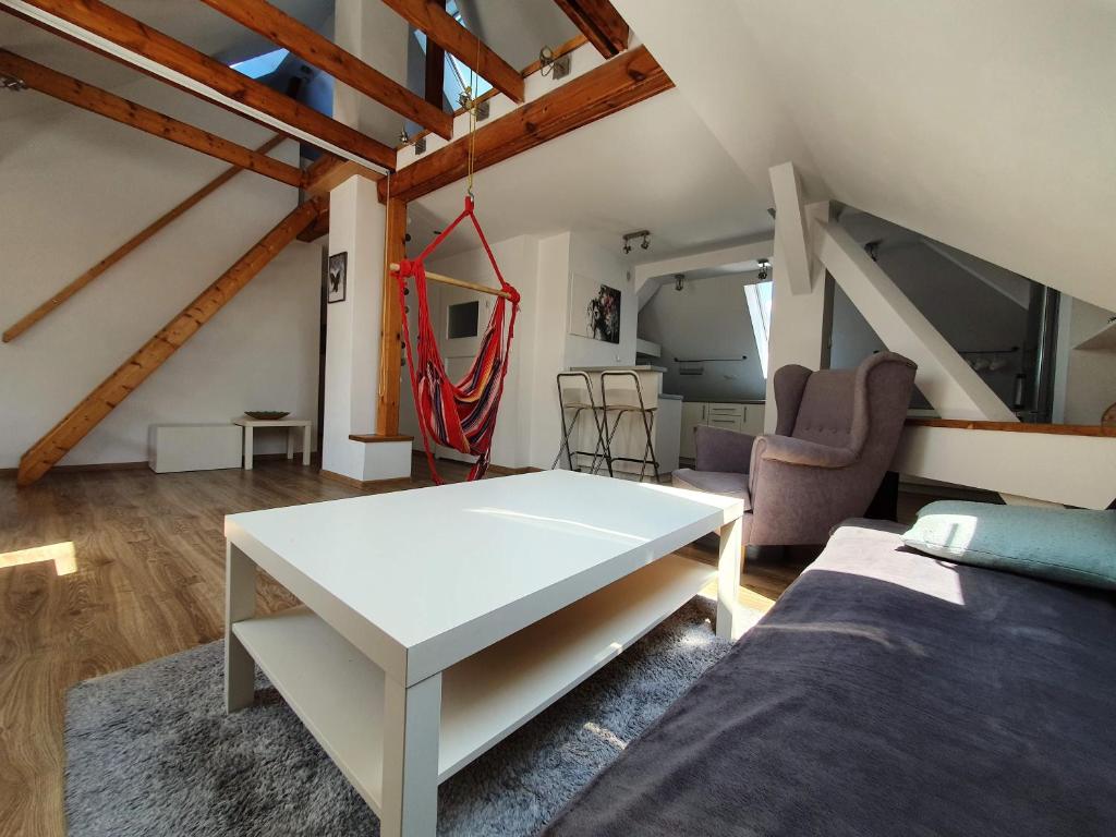 格利维采Apartament na poddaszu的一间设有白色桌子和一张床的客房