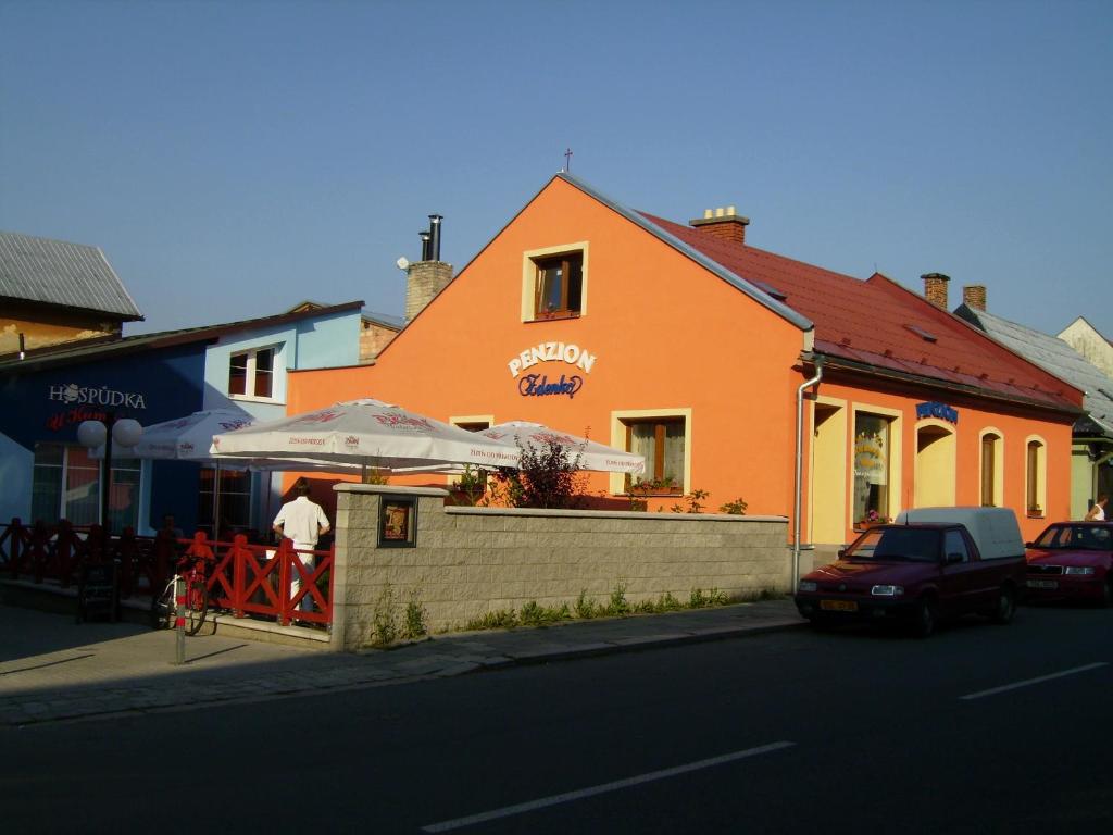 弗雷斯塔帕若德霍斯特Turistický apartmán ,pro 3-4os的站在橙色建筑外,带伞的人