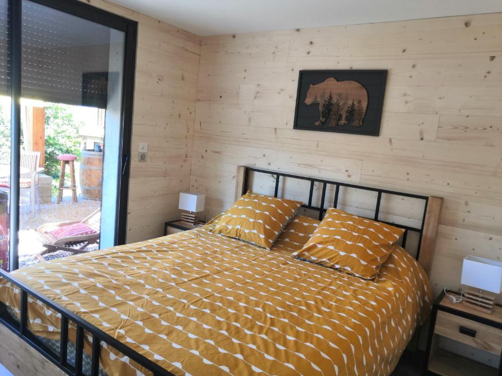 圣雷热雷梅累兹Gîtes Les Garianes的一间卧室设有一张床和木墙