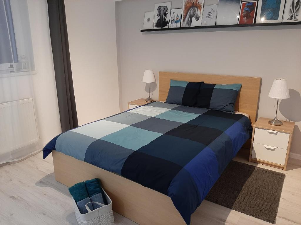 克卢日-纳波卡Light HOUSE的一间卧室配有一张带蓝色和黑色棉被的床