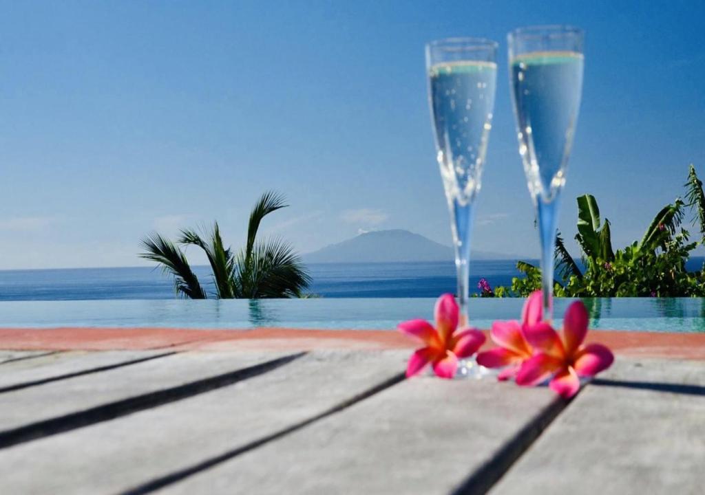 苏弗里耶尔泰德瑞什度假公寓的游泳池畔的桌子上放着两杯香槟酒和鲜花