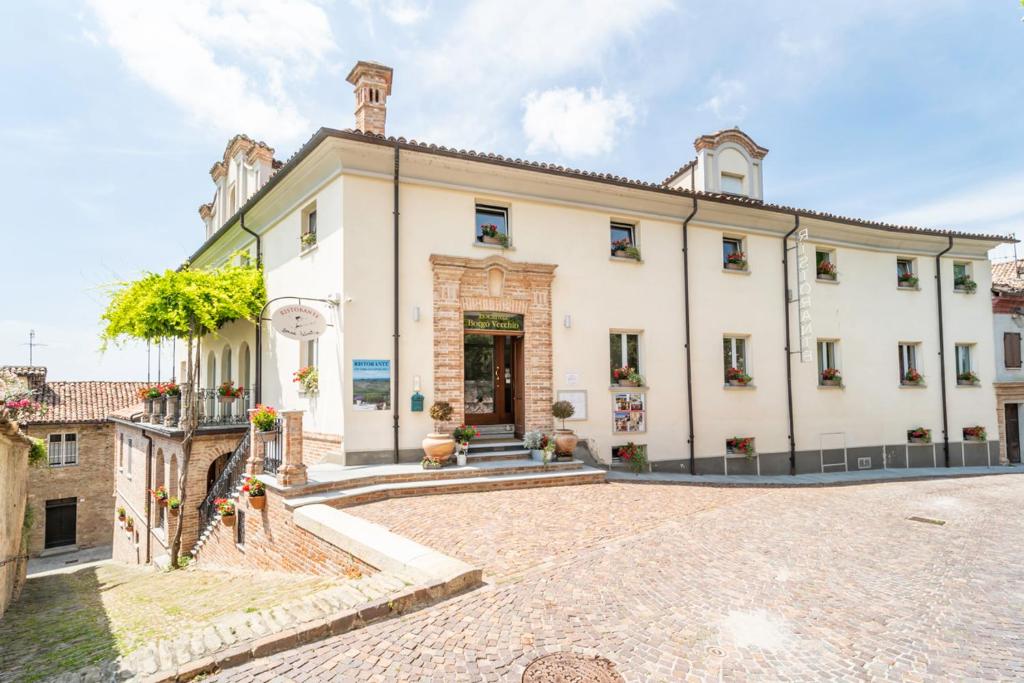 内伊韦Borgo Vecchio Locanda di Charme的享有大型白色建筑的外部景色