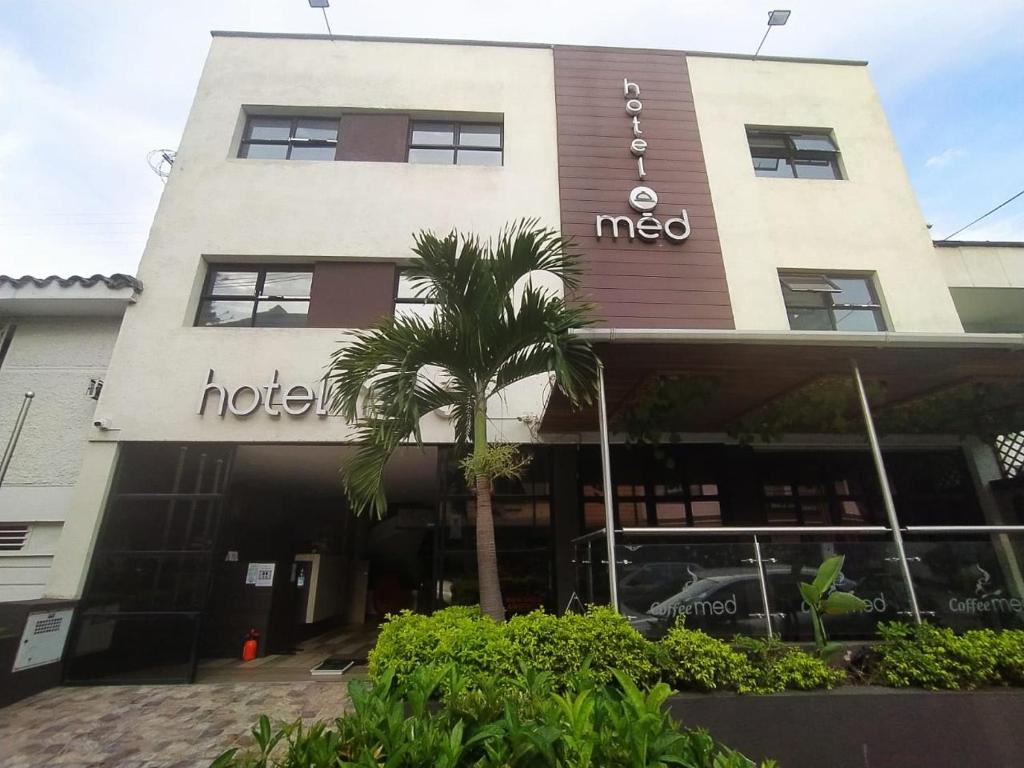 麦德林Hotel Med 70的前面有棕榈树的酒店