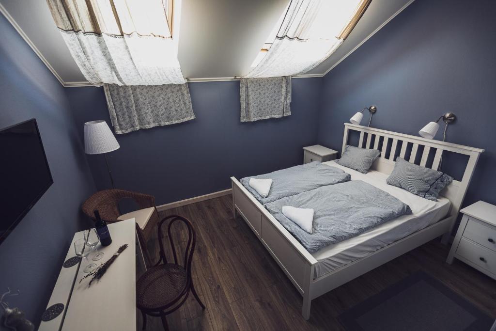 塞克萨德Kerámia - Vendégszobák的一间卧室配有一张蓝色墙壁和窗户的床