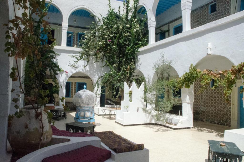 乌姆苏克杰尔巴艾瑞达酒店的一座庭院,位于一座有树木和桌子的建筑中