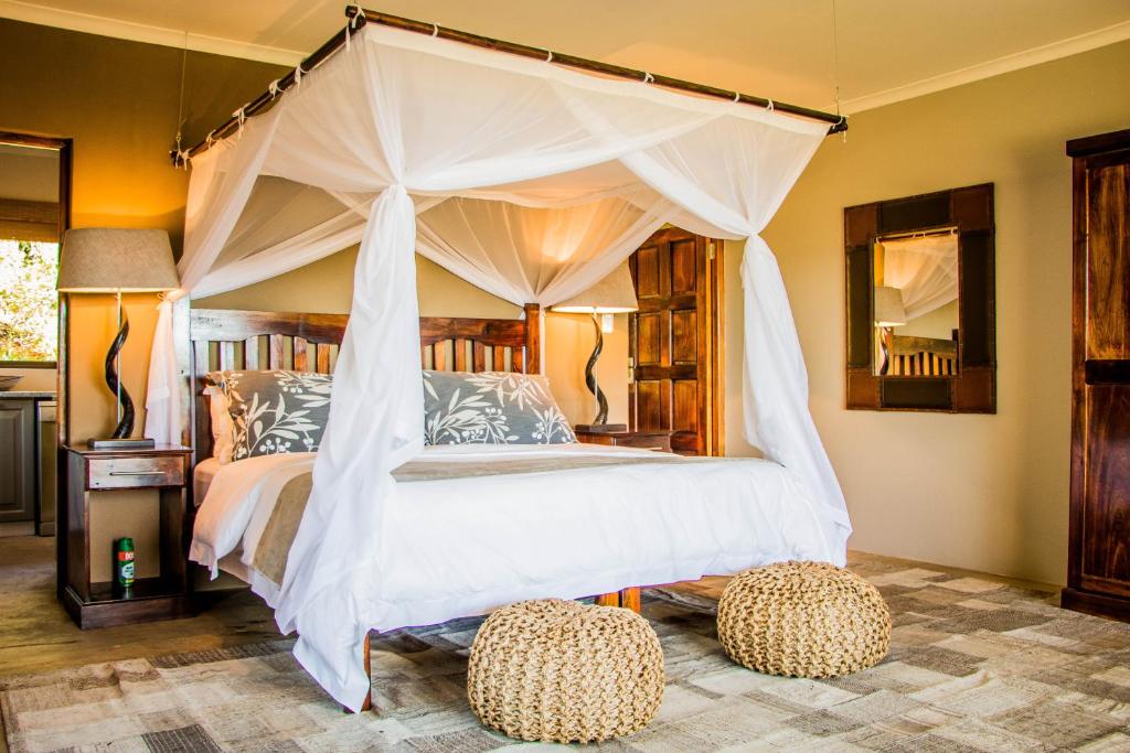 格拉罕镇African Safari Lodge的一间卧室配有一张带两张矮床的天蓬床。