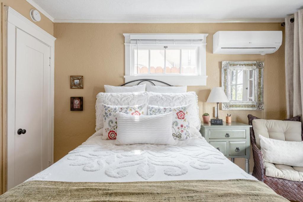 长滩Casita Charm, Cozy Character的卧室配有带枕头的白色床和窗户。