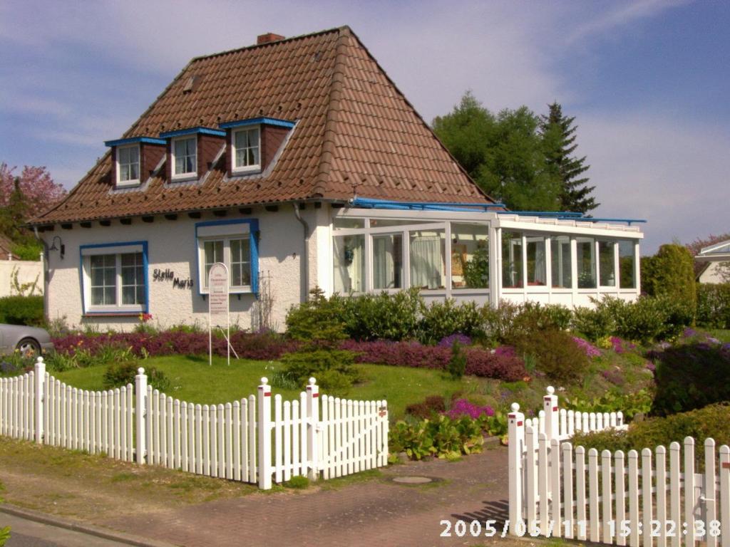 霍瓦赫特Ferienwohnungen und Ferienhaus im Nixenweg的白色栅栏的房子