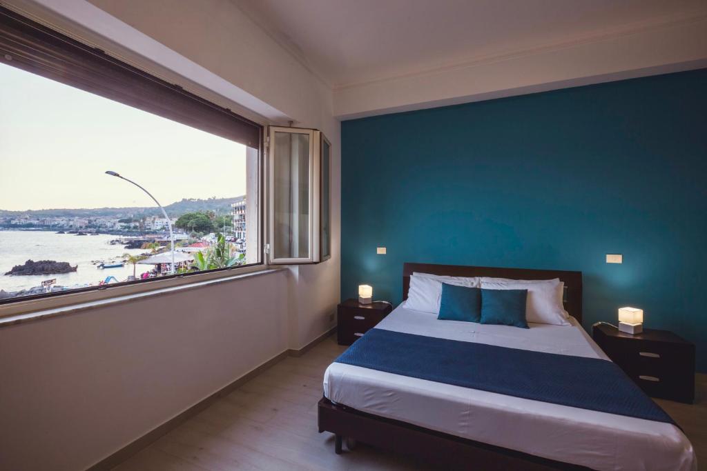 阿茨特雷扎绿洲住宿加早餐旅馆的一间卧室设有蓝色的墙壁和一张带大窗户的床。