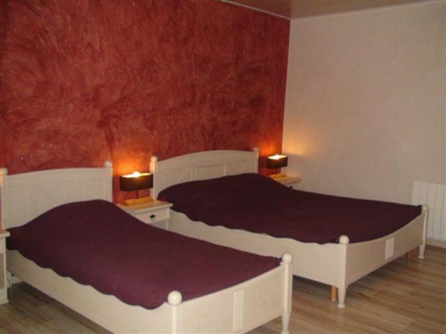 布尔日瑞维兰迪住宿加早餐旅馆的卧室设有两张床铺和红色的墙壁