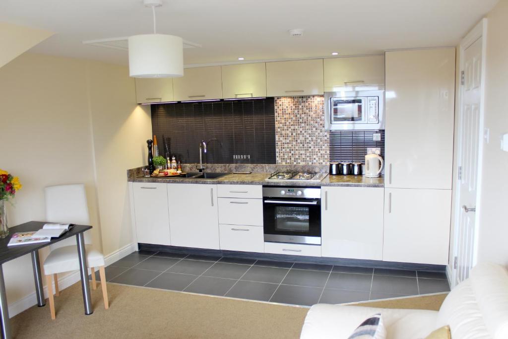 埃克塞特Silversprings - City Centre Apartments with Parking的厨房配有白色橱柜和炉灶烤箱。